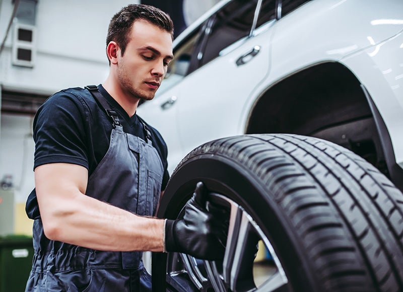 worker setting up car tire